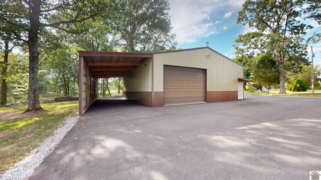 garage featuring wooden walls and a carport