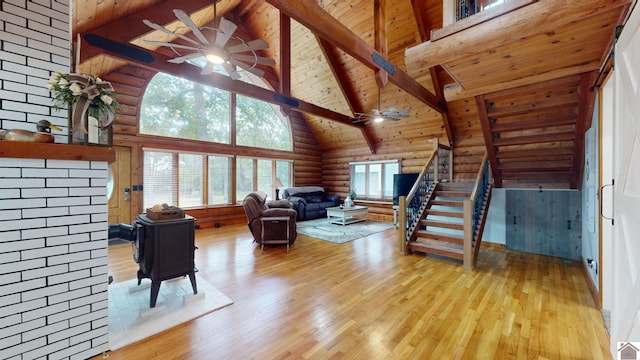 living room with light wood-type flooring, beamed ceiling, ceiling fan, and high vaulted ceiling