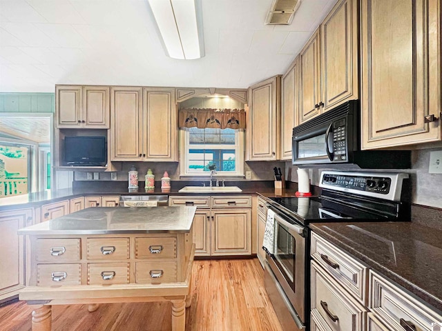 kitchen featuring a center island, sink, light hardwood / wood-style flooring, appliances with stainless steel finishes, and light brown cabinetry