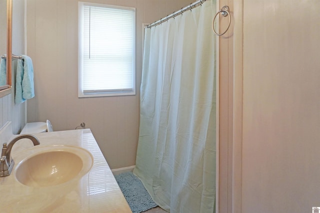 bathroom with a shower with shower curtain, toilet, and sink