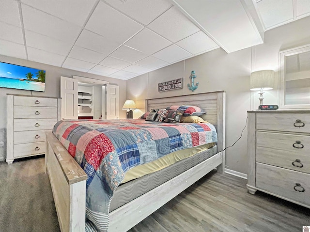 bedroom featuring a paneled ceiling and dark wood-type flooring