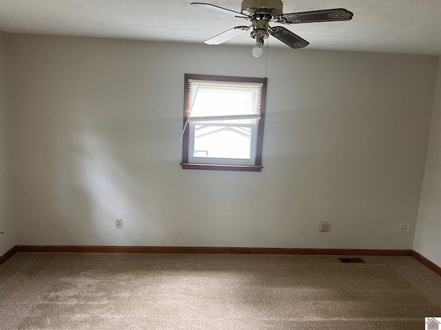 carpeted spare room with a textured ceiling and ceiling fan