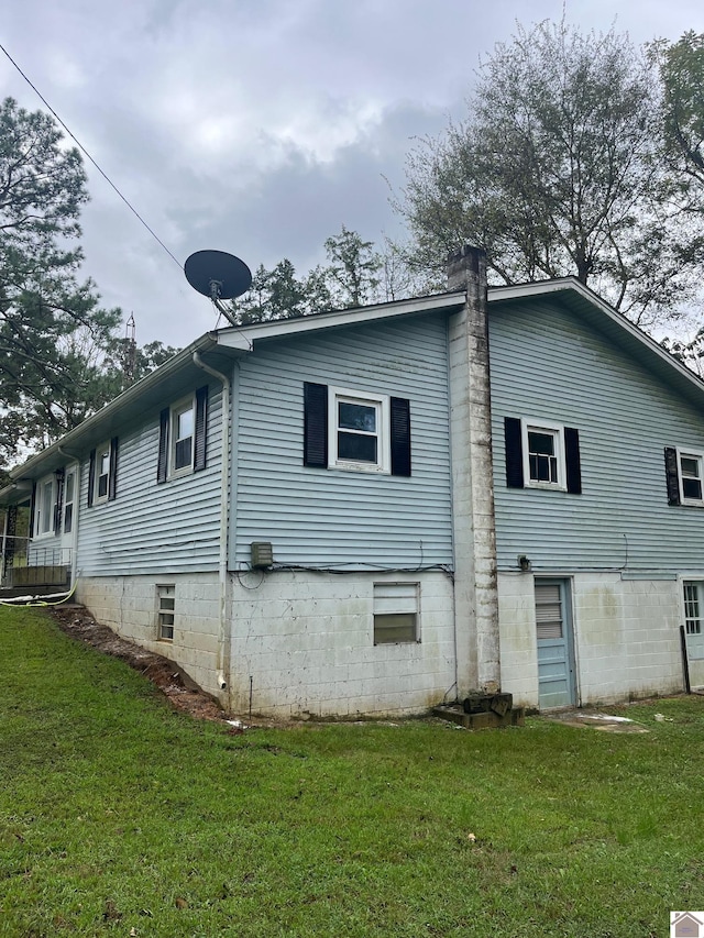 view of side of home with a yard