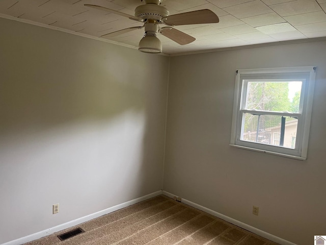 empty room with carpet flooring, ornamental molding, and ceiling fan