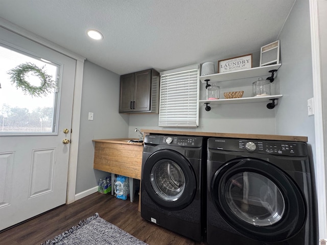 laundry area featuring separate washer and dryer, cabinets, dark wood-type flooring, and a textured ceiling