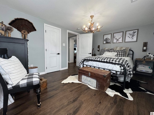 bedroom with dark hardwood / wood-style floors and a notable chandelier