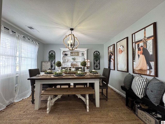 carpeted dining space featuring a notable chandelier and a textured ceiling