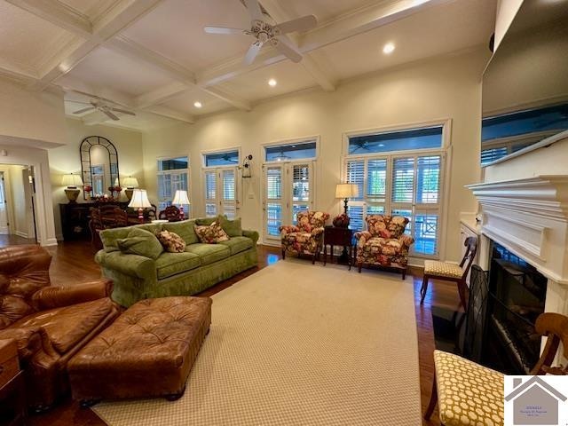 living room with ceiling fan, hardwood / wood-style flooring, beam ceiling, and coffered ceiling