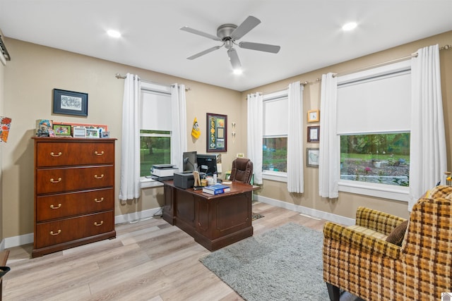 home office with ceiling fan, light wood-type flooring, and a healthy amount of sunlight