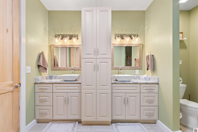 bathroom with tile patterned flooring, vanity, and toilet