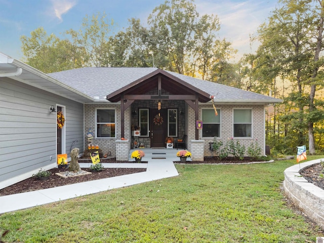 ranch-style house featuring covered porch and a front yard