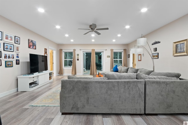 living room with light hardwood / wood-style floors and ceiling fan