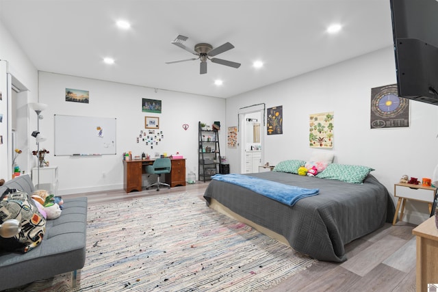 bedroom with ceiling fan, ensuite bath, and light hardwood / wood-style floors