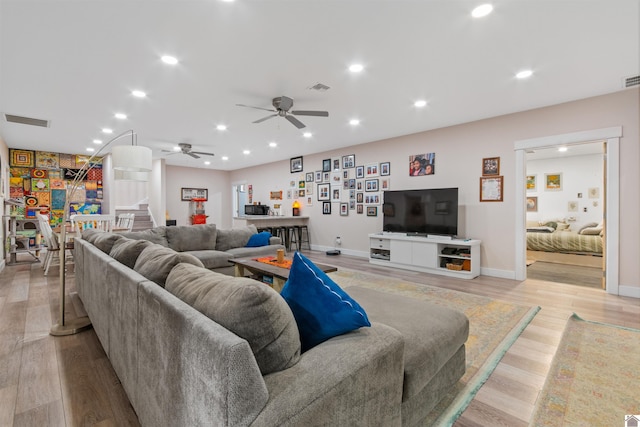 living room with light wood-type flooring and ceiling fan