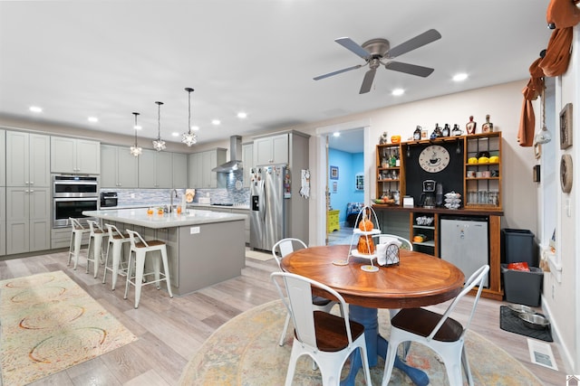 dining room with light wood-type flooring and ceiling fan