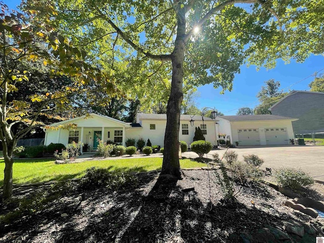 ranch-style house featuring a garage and a front lawn