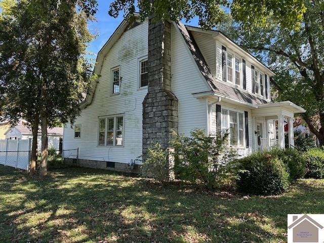 view of side of home with a yard