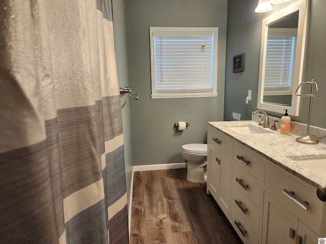 bathroom with a shower with shower curtain, vanity, hardwood / wood-style floors, and toilet