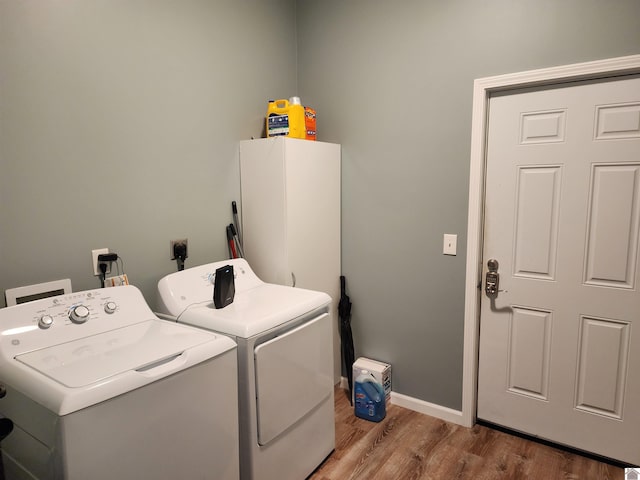 clothes washing area with hardwood / wood-style floors and washing machine and clothes dryer