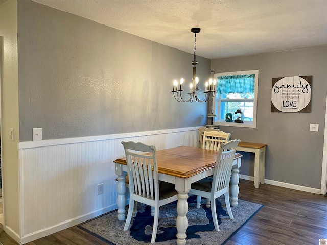 dining room with a textured ceiling, dark hardwood / wood-style floors, and a notable chandelier