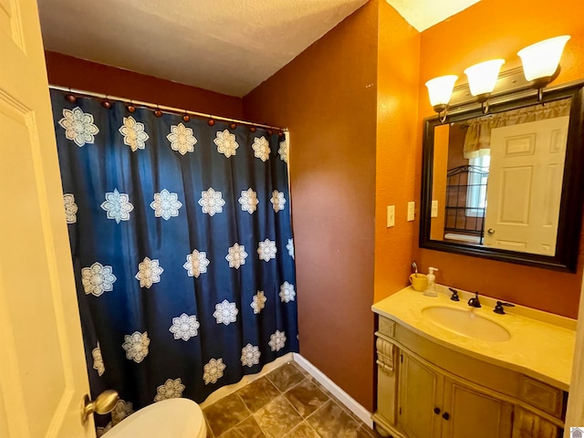 bathroom featuring a textured ceiling, curtained shower, vanity, and toilet