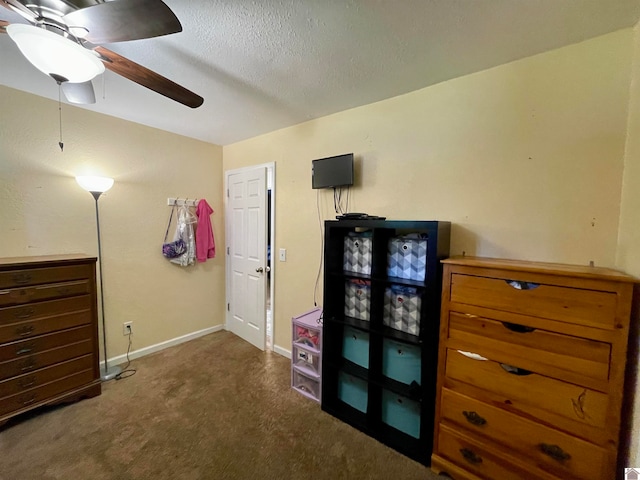 bedroom featuring ceiling fan, a textured ceiling, and dark carpet