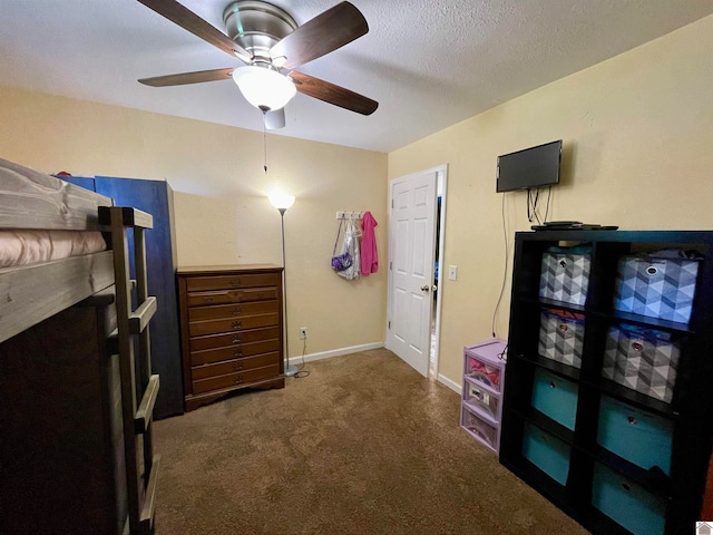 bedroom with a textured ceiling, dark carpet, and ceiling fan