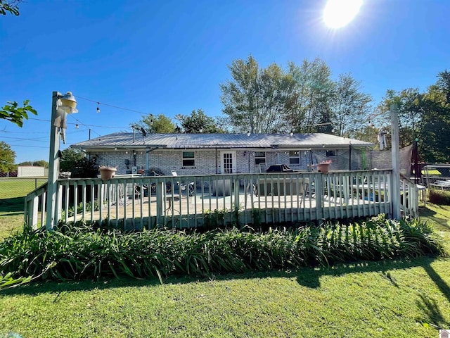 rear view of house featuring a yard and a wooden deck