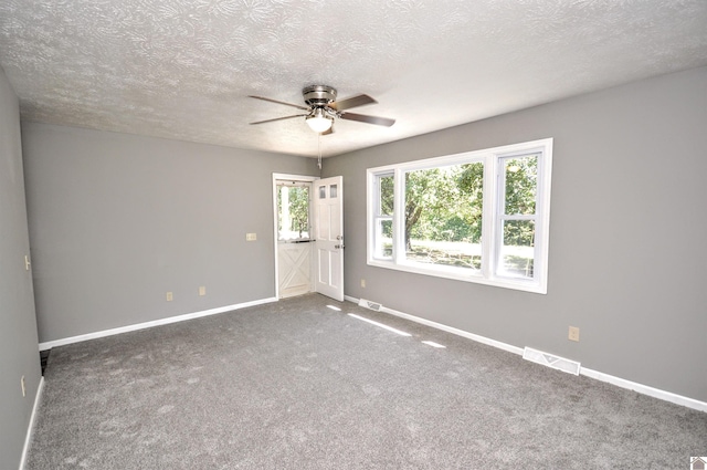 spare room featuring carpet floors, a textured ceiling, and ceiling fan