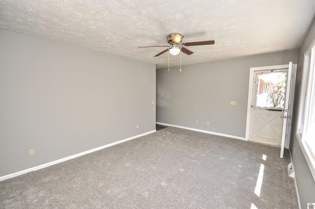 carpeted empty room featuring a textured ceiling and ceiling fan