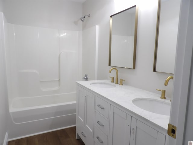 bathroom featuring wood-type flooring, tub / shower combination, and vanity