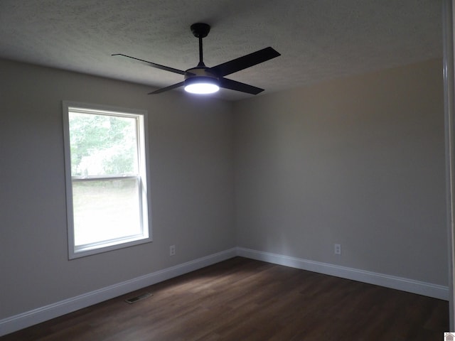 empty room with dark wood-type flooring, a textured ceiling, and ceiling fan