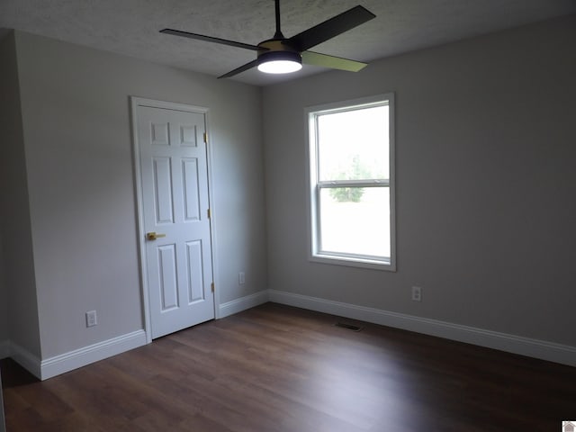 unfurnished room featuring ceiling fan, a textured ceiling, and dark hardwood / wood-style flooring