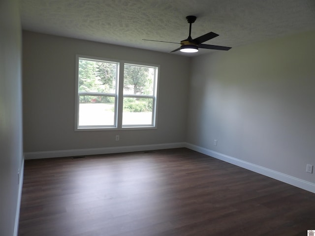 empty room featuring ceiling fan, dark hardwood / wood-style floors, and a textured ceiling