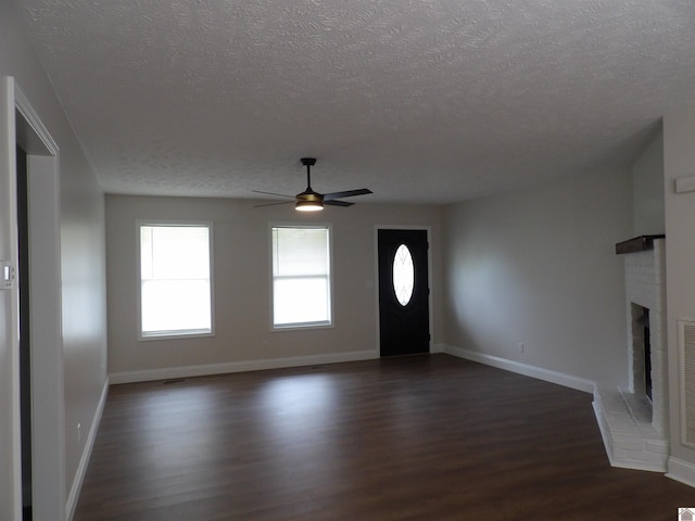 foyer with ceiling fan, a textured ceiling, and dark hardwood / wood-style flooring