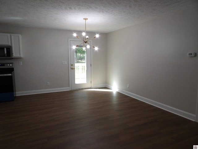 unfurnished dining area featuring dark hardwood / wood-style floors, a chandelier, and a textured ceiling