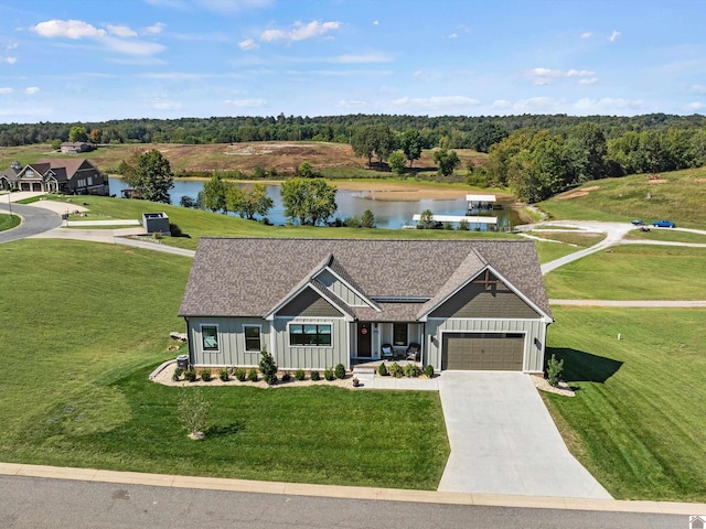 view of front of property featuring a garage, a water view, and a front lawn