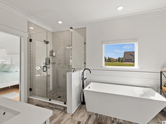 bathroom featuring independent shower and bath, crown molding, and wood-type flooring