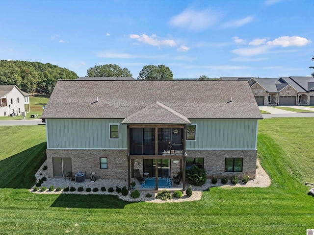 back of house featuring a lawn, central AC, and a balcony