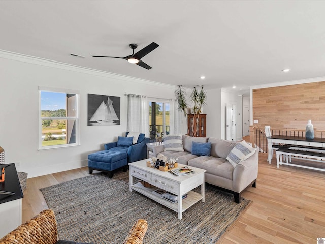 living room with ornamental molding, plenty of natural light, and light hardwood / wood-style floors