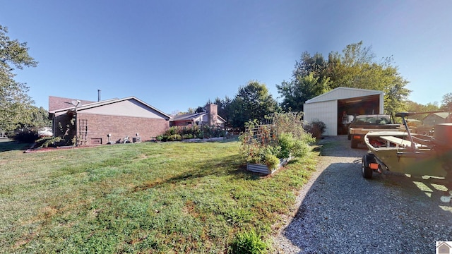 view of yard featuring a garage and an outbuilding