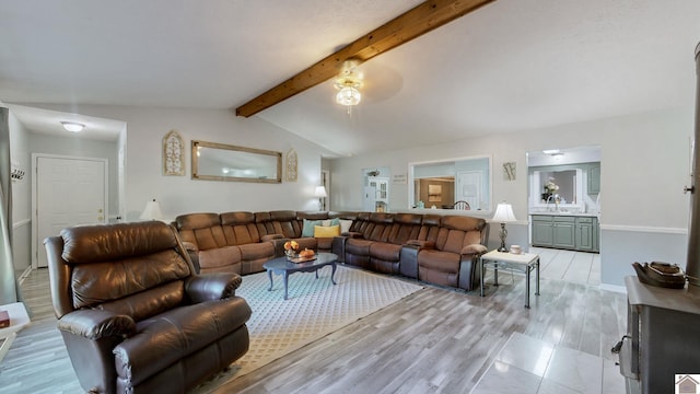 living room featuring light wood-type flooring, vaulted ceiling with beams, sink, and ceiling fan