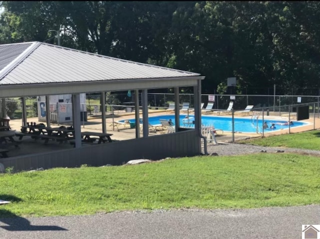 view of pool with a patio and a yard