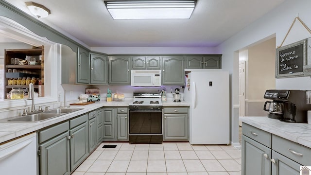 kitchen with white appliances, sink, and light tile patterned floors