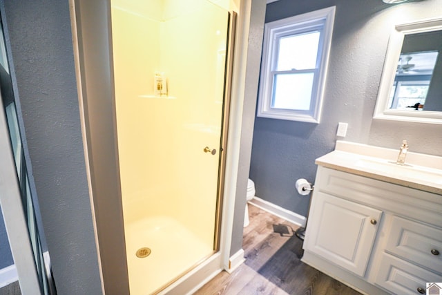 bathroom featuring hardwood / wood-style floors, a shower, vanity, and toilet