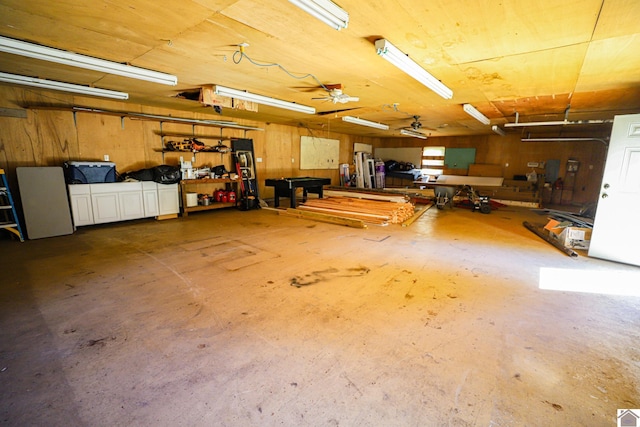 garage with wood walls and ceiling fan