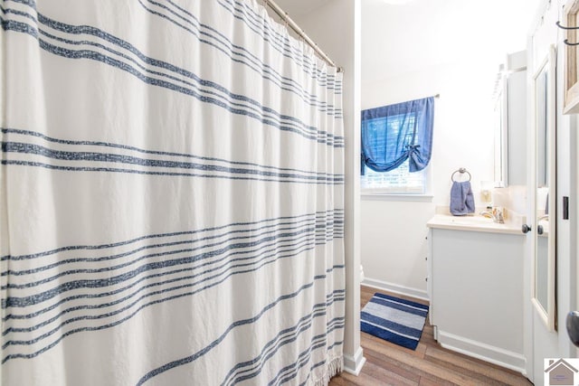 bathroom with wood-type flooring, vanity, and a shower with shower curtain