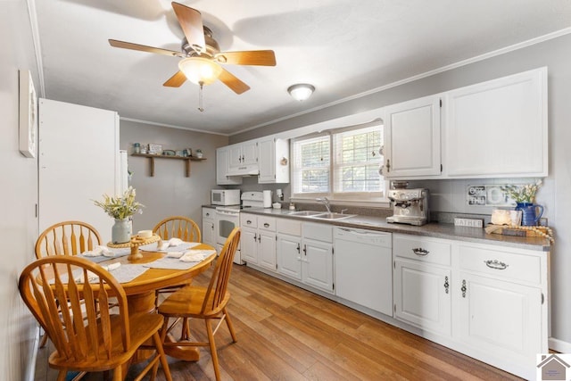 kitchen featuring white appliances, sink, light hardwood / wood-style flooring, and white cabinets