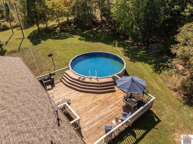 view of swimming pool featuring central AC unit, a deck, and a lawn