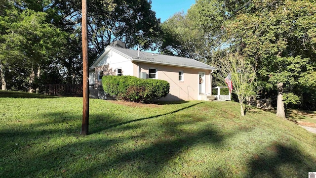 view of side of property with a lawn